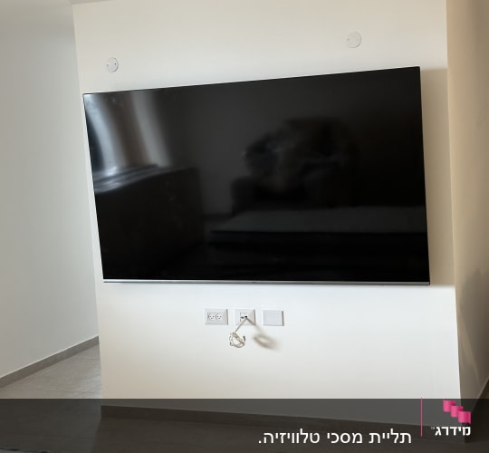 טלוויזיה מותקנת על קיר עם שקעים חשמליים